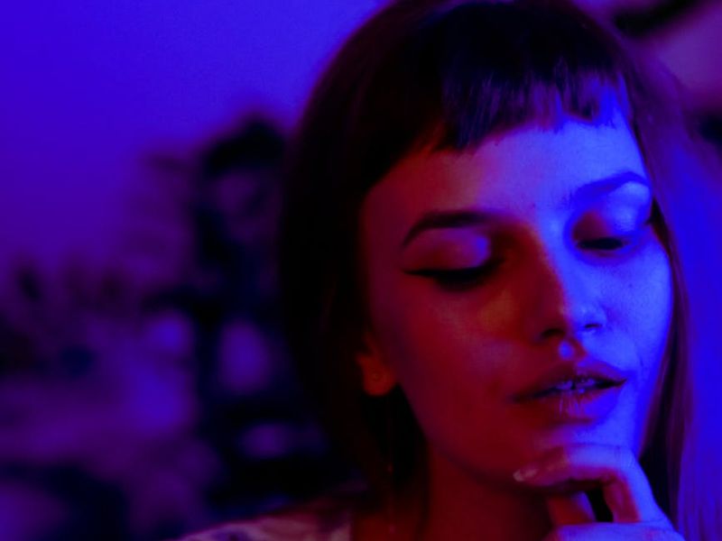 Close up of a calm eye reflecting neon violet light